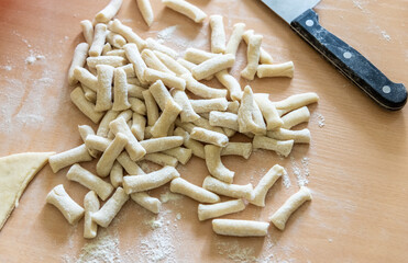 Raw dough or noodle pieces on wooden table