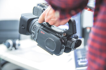 Professional film production: Male filmmaker is recording with a professional movie camera. Close...