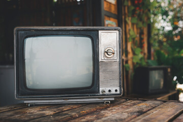 Old-fashioned TV on wooden table at vintage home, outdoors