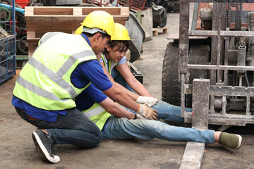 Accident at workplace, industrial engineer worker wearing helmet hit by forklift car at...