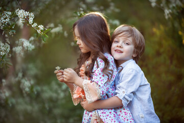 Beautiful twins boy and girl in spring garden - 424776188