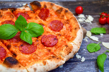 Home made italian  pepperoni   pizza with  tomatoes, mozzarella and parmesan cheese and fresh basil 