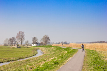 Fototapeta na wymiar Little white house at the bicycle path in the Zaanstreek in The Netherlands