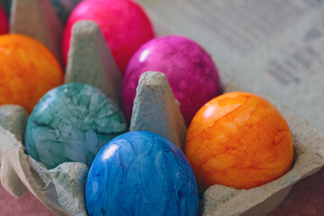 Easter colored eggs in a cardboard box.