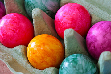 Easter colored eggs in a cardboard box.