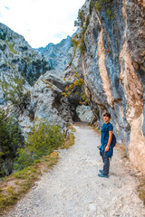Naklejka premium A young woman on the trail in the Picos de Europa, on the Cares route. Asturias