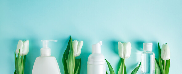 Skin care products on a blue background. Natural cosmetics and white tulips.