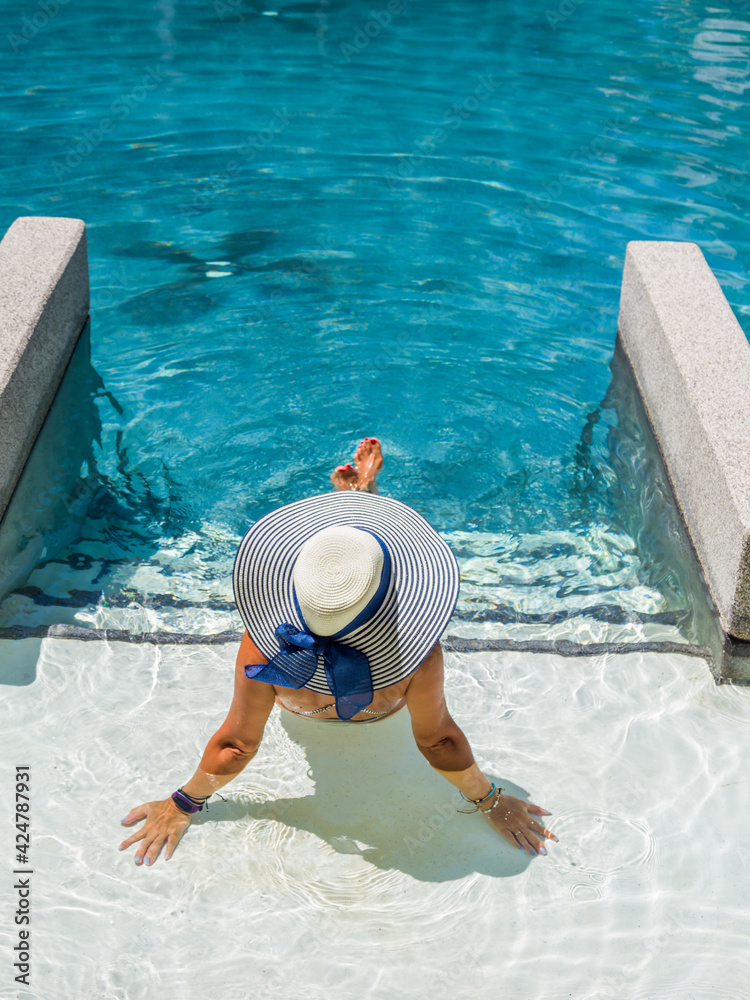 Poster woman in luxury spa resort near the swimming pool.