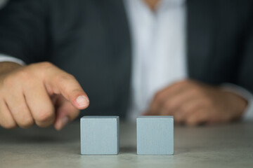 Finger of Businessman in suit touch to wood block