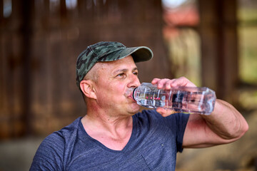 working man is hydrated after the effort made to cut wood