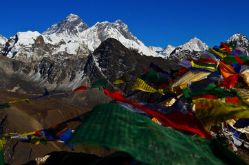Prayer flags on top of Gokyo Ri (5.360m) and three of the five highest mountains in the world:  Mt Everest (8.848m), Lhotse (8.516m) and Makalu (8.462m). Solukhumbu, Sagarmatha National Park, Nepal.