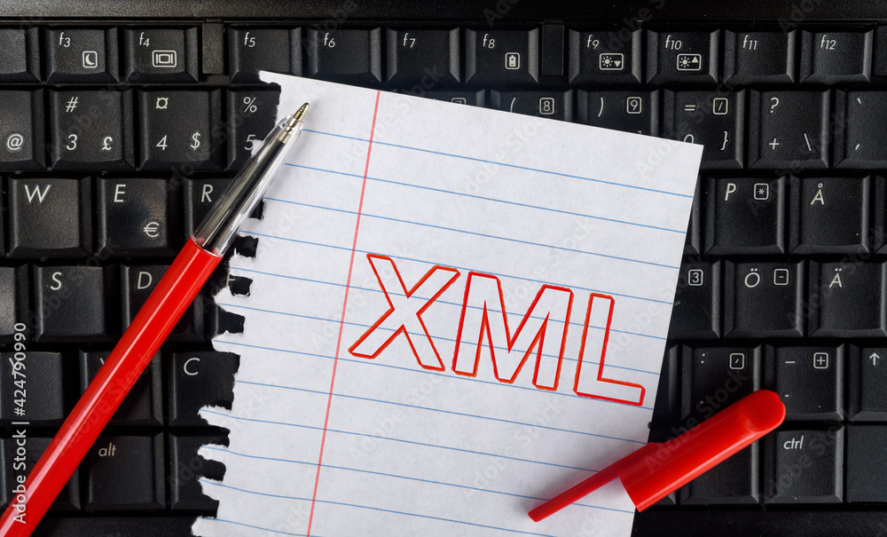 Poster extensible markup language. word xml on laptop and paper with pencil
