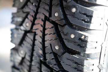 Auto tire for passenger car winter, with spikes. Tread, close-up, horizontal