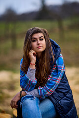 Fototapeta premium portrait of a young woman wearing a hooded jacket with nature in the background
