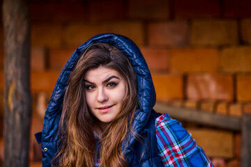 Girl posing against background of an old red brick wall.