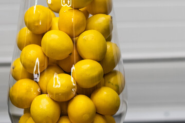 lemons in a glass vase on a white background