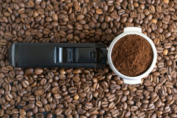Ground coffee in a horn among the beans. Home coffee making concept. Horizontal orientation. Top view.