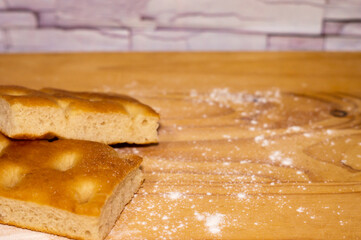 Italian Focaccia bread on a table with flour