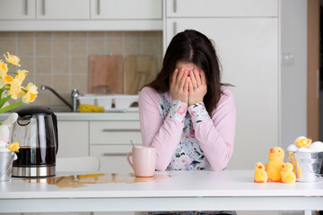 Tired mother, trying to pour coffee in the morning. Woman lying on kitchen table after sleepless night