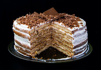 Cake with cottage cheese cream and chocolate chips. With a cut-out piece.