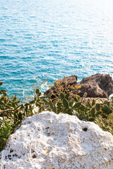 Mediterranean Sea concept. White stone rock above Azur seawater. Selective focus on the stone. 