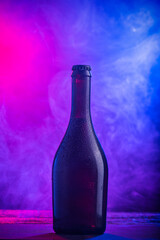 A ottles of beer on colorful smoke dark background