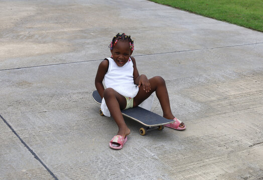 Happiness Daughter playing Skateboard on street at home.