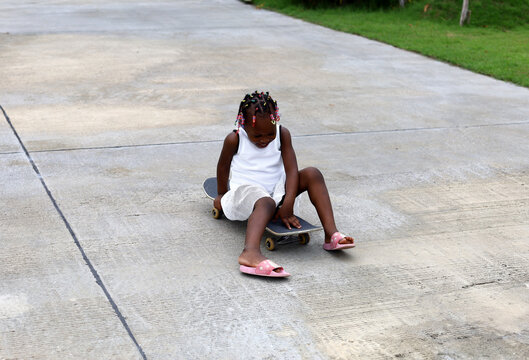 Happiness Daughter Playing Skateboard On Street At Home.