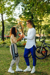 Vertical photo of a funny playful couple messing around in the city park, having fun, laughing,...