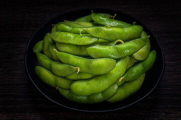 Edamame boiled green soy beans with sea salt on table, traditional Japanese food