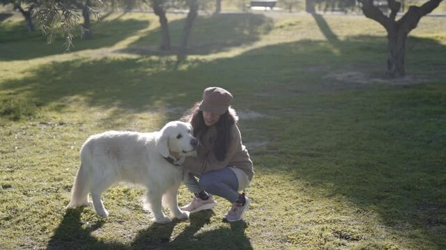 Mixed race woman having fun with Golden retriever