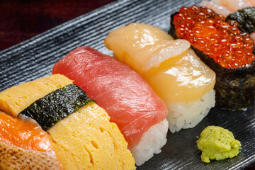 setting of sushi rolls with caviar and chopped fresh fish on background, Asian food, traditional Japanese food