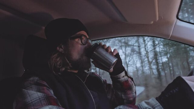 Bearded Man In Glasses Driving And Drinking Coffee