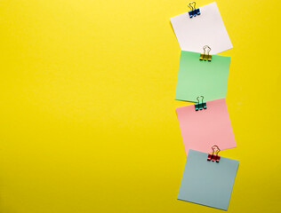 Paper layout. Clips with a paper card template on a yellow background for text or image.Promotions and discounts theme. Copyspace. Spare photo. View from above.Selective focus.