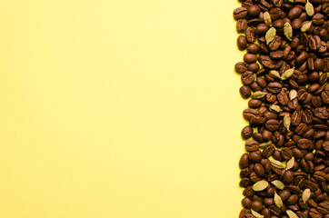 Fragrant сoffee beans, cardamom on a yellow background. Place for your text.