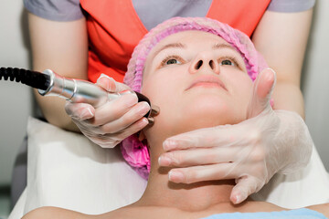 Naklejka premium Close-up portrait of a beautiful woman with her eyes closed getting RF-lifting