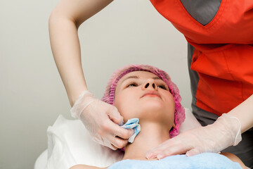 A woman lies down and prepares to undergo a cosmetic or clinical procedure.