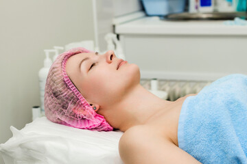 Obraz na płótnie Canvas A woman lies down and prepares to undergo a cosmetic or clinical procedure.