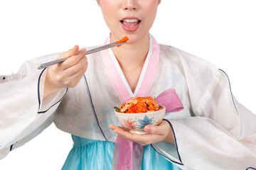 Women wearing Korean Hanbok dress eating Kimchi isolate on white background. Attractive woman is eating Kimchi with chopstick. Asian woman holding Kimchi and eating by chopsticks while wearing Hanbok.