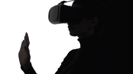 Driving simulator. Virtual reality. Computer game. Cyber technology. Futuristic innovation. Silhouette woman wearing vr glasses using program for study isolated on white copy space.