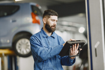  ar mechanic with a tablet near car in work clothes