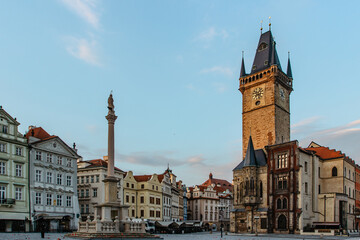 Fototapeta premium Old Town Square in Prague, Czech Republic. Empty city during sunrise without people surrounded by historical, gothic style buildings and the famous Astronomical Clock Tower.Beautiful urban scene