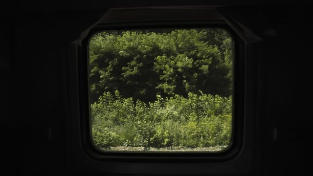 Tourist train trip. Summer landscape from the window of a speeding train. Fast moving train. Railroad running through green fields. Passion for travel. Way home.