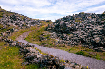 Trail through the lava field in a black rock volcanic environment in Snæfellsnes peninsula in Eastern Iceland