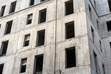 Fototapeta na wymiar Facade of abandoned construction site of a multi storey building with no windows.