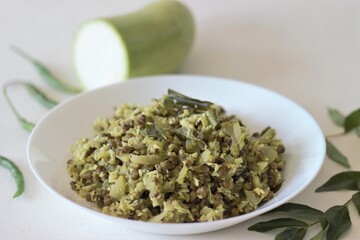 Stir fried Bottle gourd and green gram. A dish made with chopped vegetables and pulsed grated coconut with shallots, green chillies, turmeric and curry leaves in coconut oil. Locally known as Thoran