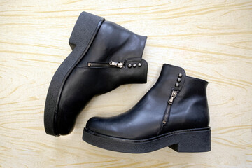 Black women's ankle boots with zippers and buttons on a thick sole
