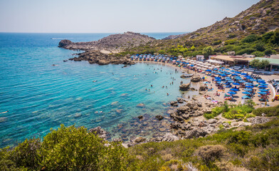 Beautiful Ladiko bay Beach with clear blue water near Faliraki, Rhodes island, Greece on a sunny summer day.