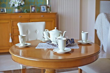 Fototapeta na wymiar English tea party, table for the living room. Beautiful white dinner service. porcelain teapot and cups