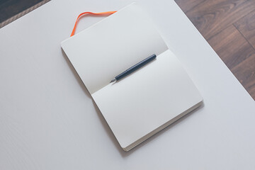 notebook with fountain pen on white table